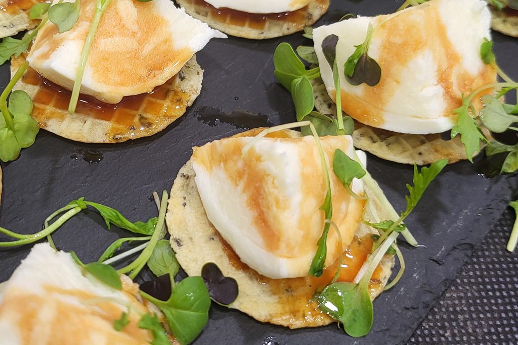 Presentació de base amb alfàbrega i oli d'oliva amb burrata i umami de tomàquet.